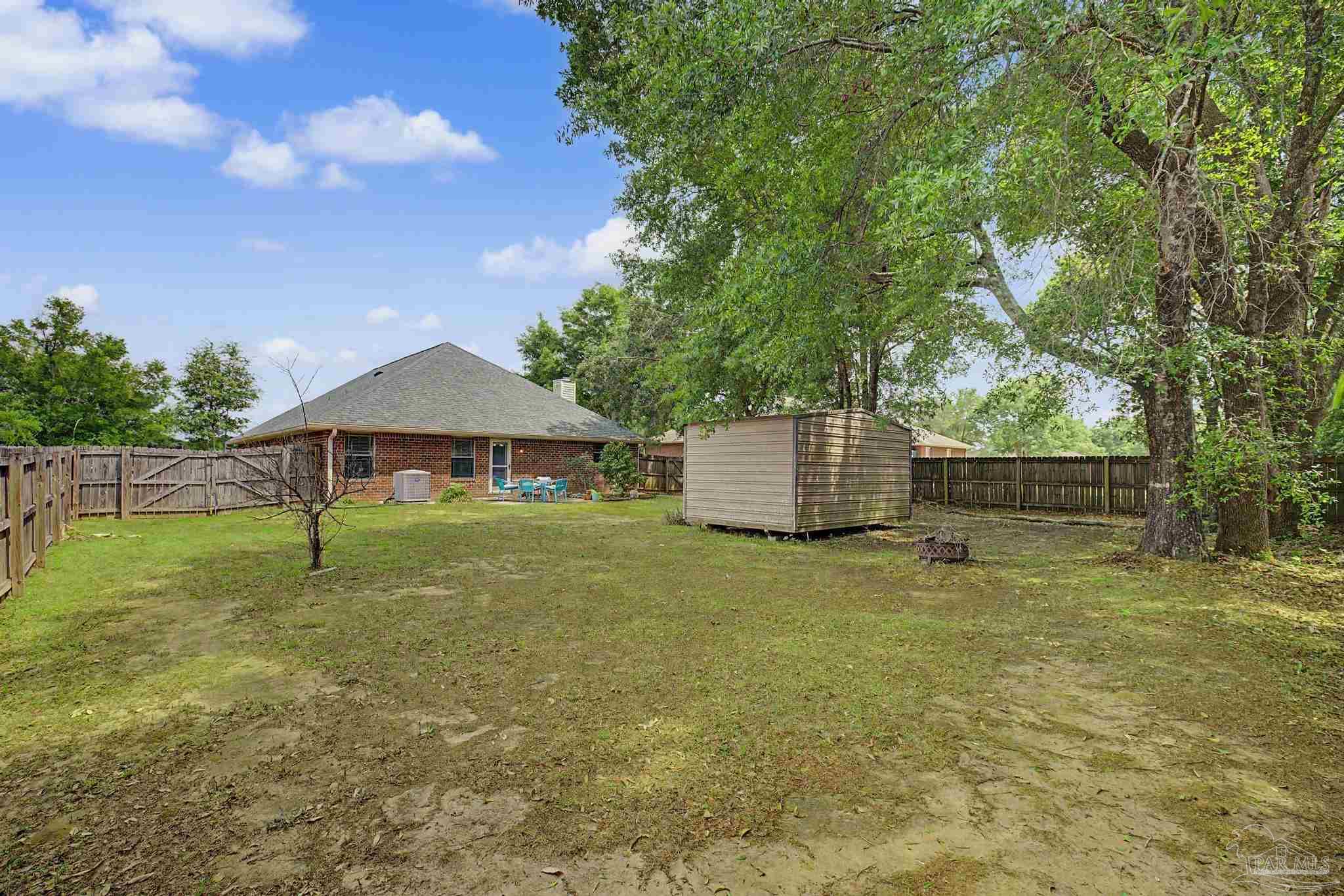 5461 Tucker Circle Pace, FL 32571 - Photo 39 of 52 a backyard of a house with table and chairs