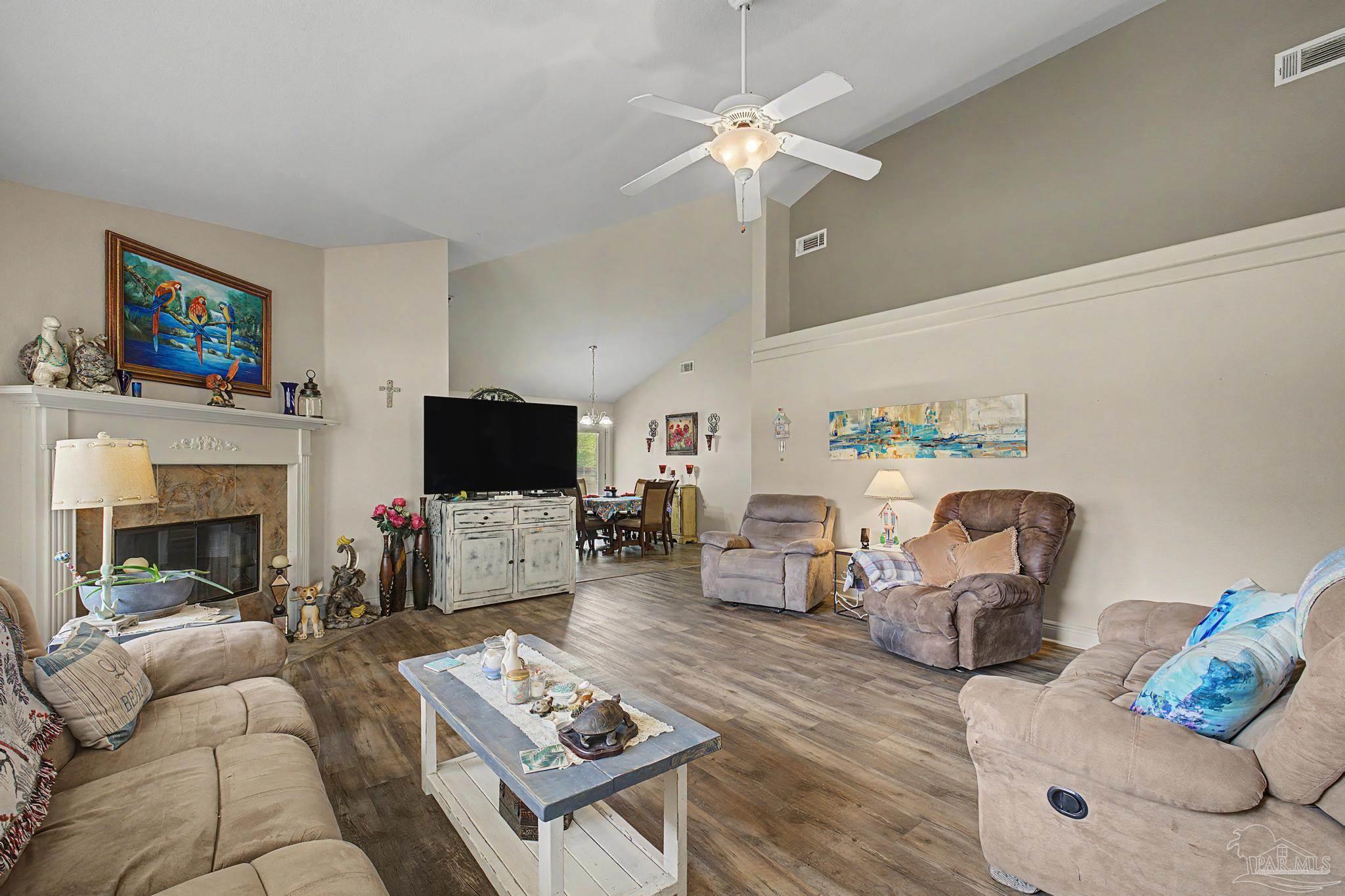 5461 Tucker Circle Pace, FL 32571 - Photo 4 of 52 a living room with furniture a fireplace and a flat screen tv