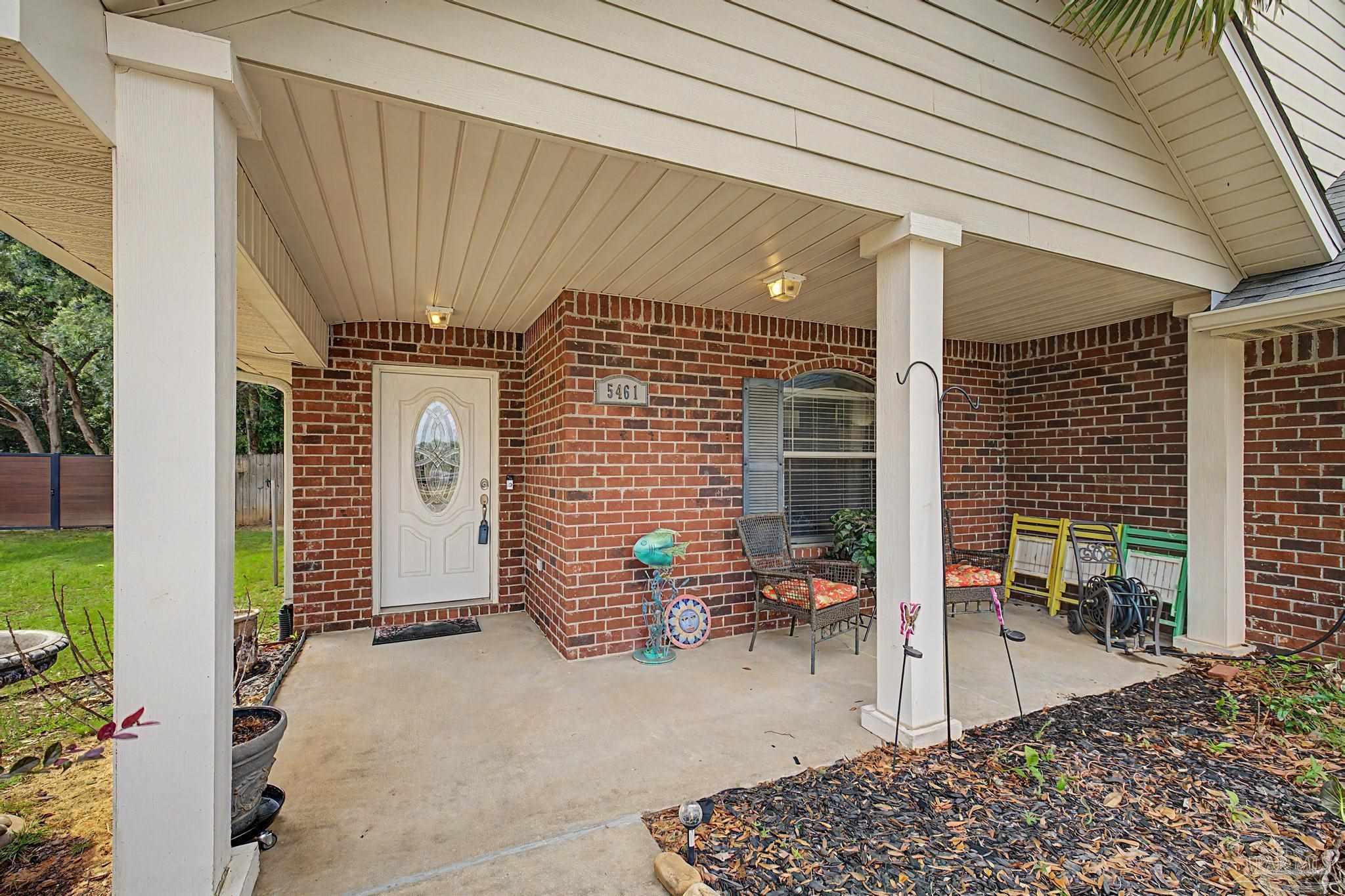 5461 Tucker Circle Pace, FL 32571 - Photo 43 of 52 a view of a patio with table and chairs and potted plants