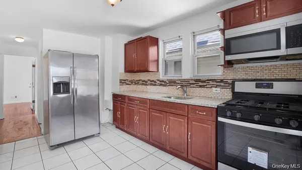 a kitchen with stainless steel appliances granite countertop a stove a sink and a microwave
