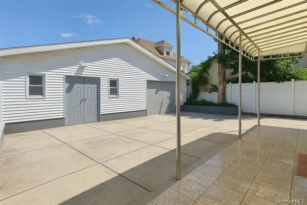 a view of a white house with large windows and a small yard