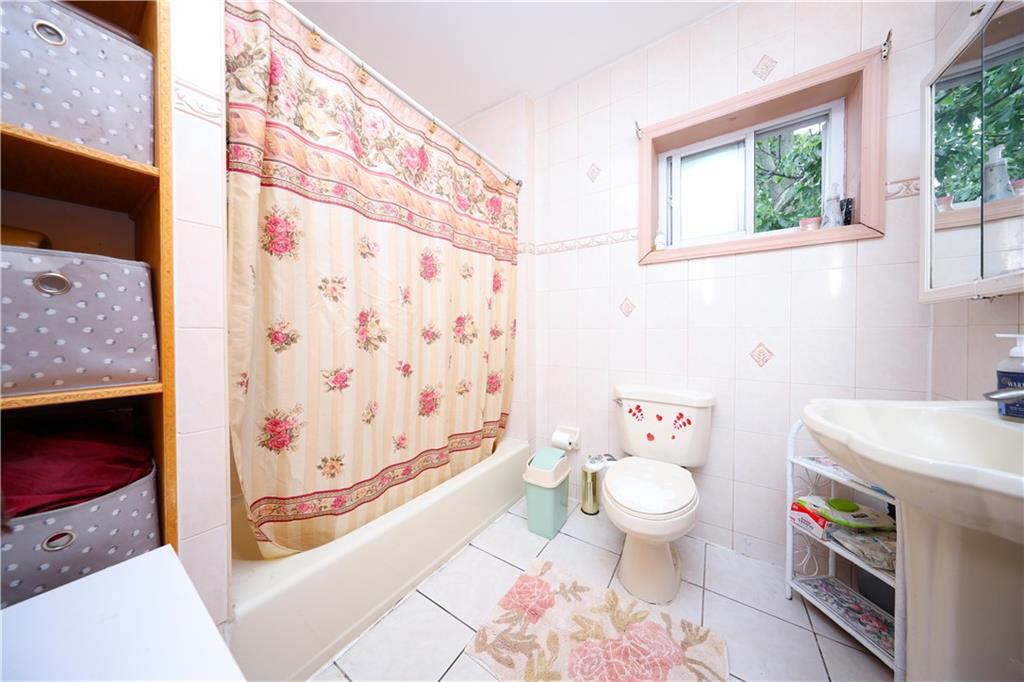 2667 Cropsey Avenue Brooklyn, NY 11214 - Photo 16 of 40 a bathroom with a sink toilet and shower