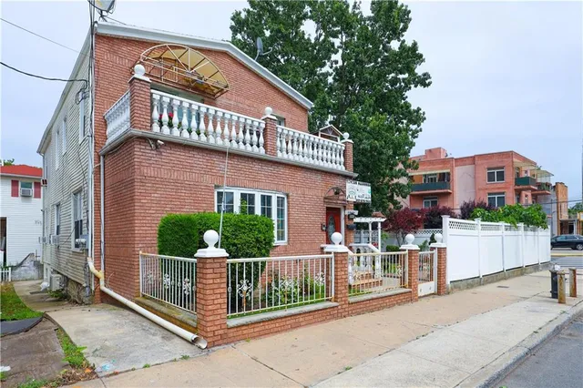 a view of a house with a small yard and wooden fence