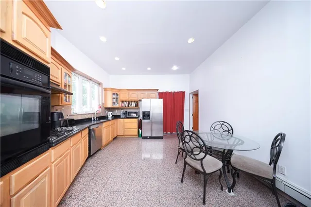 a kitchen with stainless steel appliances kitchen island granite countertop a table and chairs
