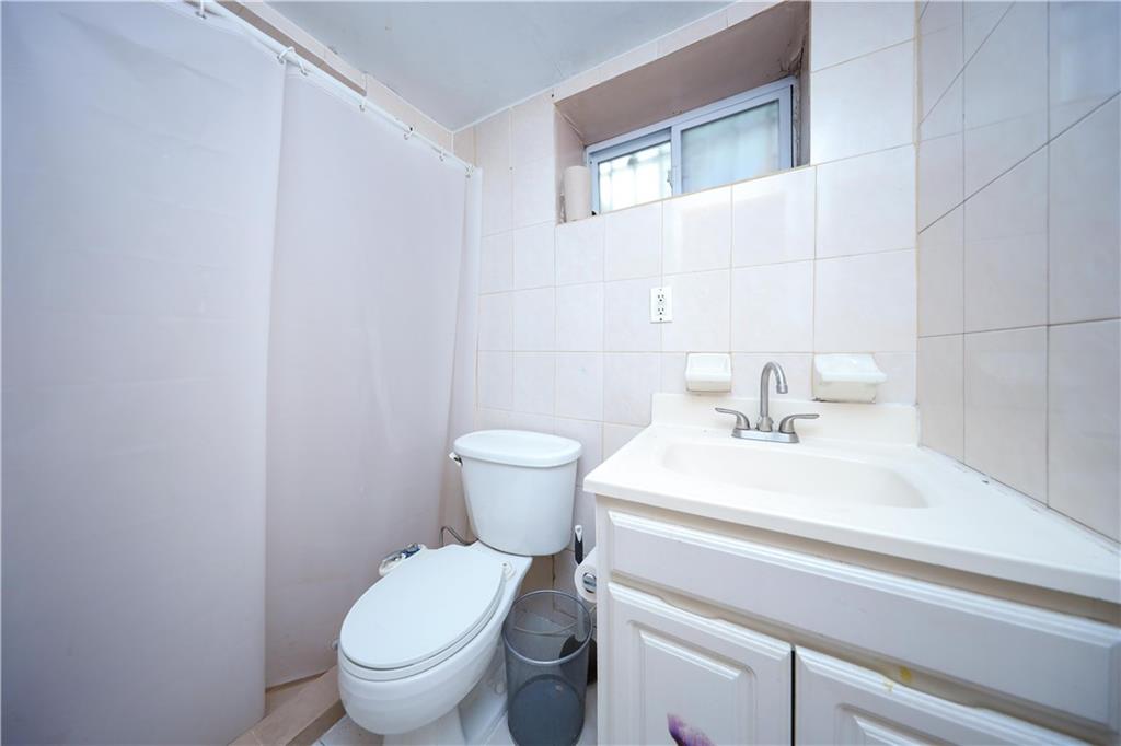 2667 Cropsey Avenue Brooklyn, NY 11214 - Photo 33 of 40 a bathroom with a sink toilet and a mirror