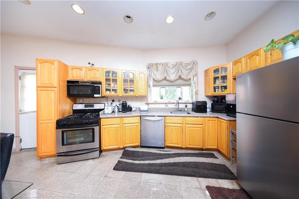 2667 Cropsey Avenue Brooklyn, NY 11214 - Photo 10 of 40 a kitchen with stainless steel appliances granite countertop a refrigerator a stove and a sink with couches