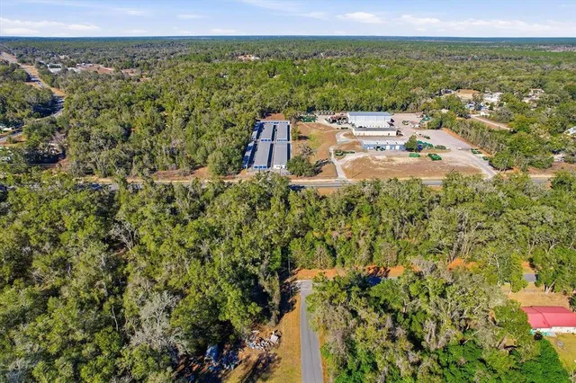 an aerial view of a house with a yard and lake view
