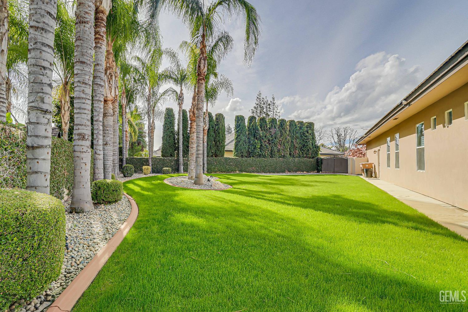 Undisclosed Address Bakersfield, CA 93311 - Photo 41 of 41 a view of a white house with a big yard and potted plants