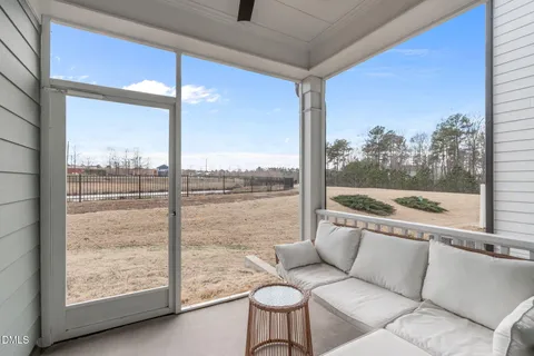 a living room with furniture a flat screen tv and a large window
