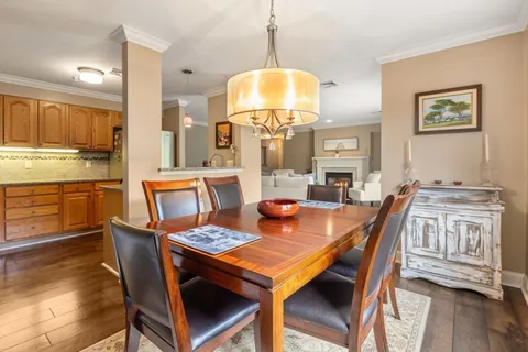 a dining room with a table chairs and a kitchen view