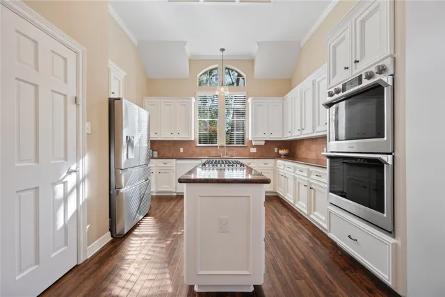 a kitchen with granite countertop a stove oven and a refrigerator