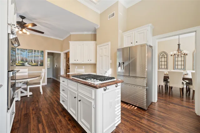 a kitchen with a refrigerator a stove top oven a counter space and wooden floor