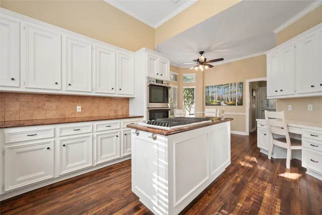 a kitchen with stainless steel appliances granite countertop a stove and white cabinets