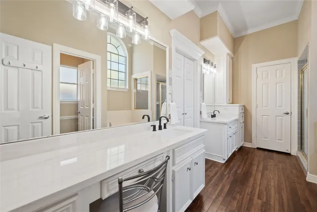 a spacious bathroom with a double vanity sink a mirror and a shower