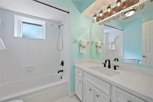 a bathroom with a tub a sink and mirror