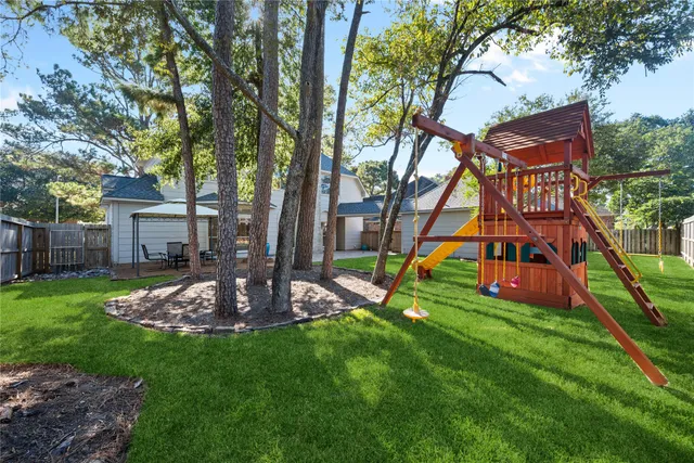 a view of a house with backyard and a tree