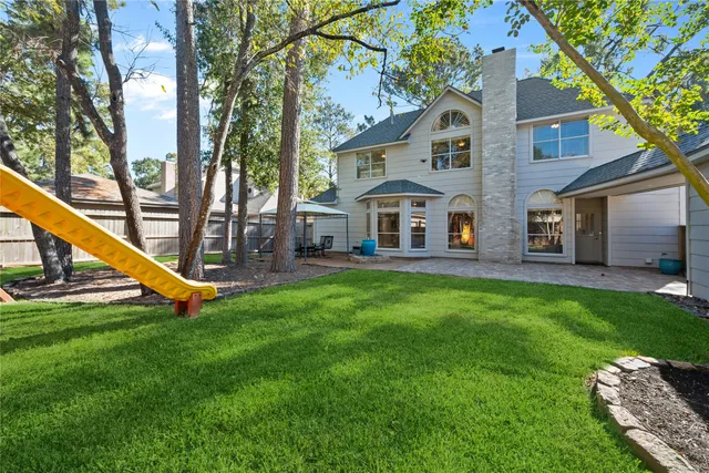 a view of a house with a yard porch and a large tree