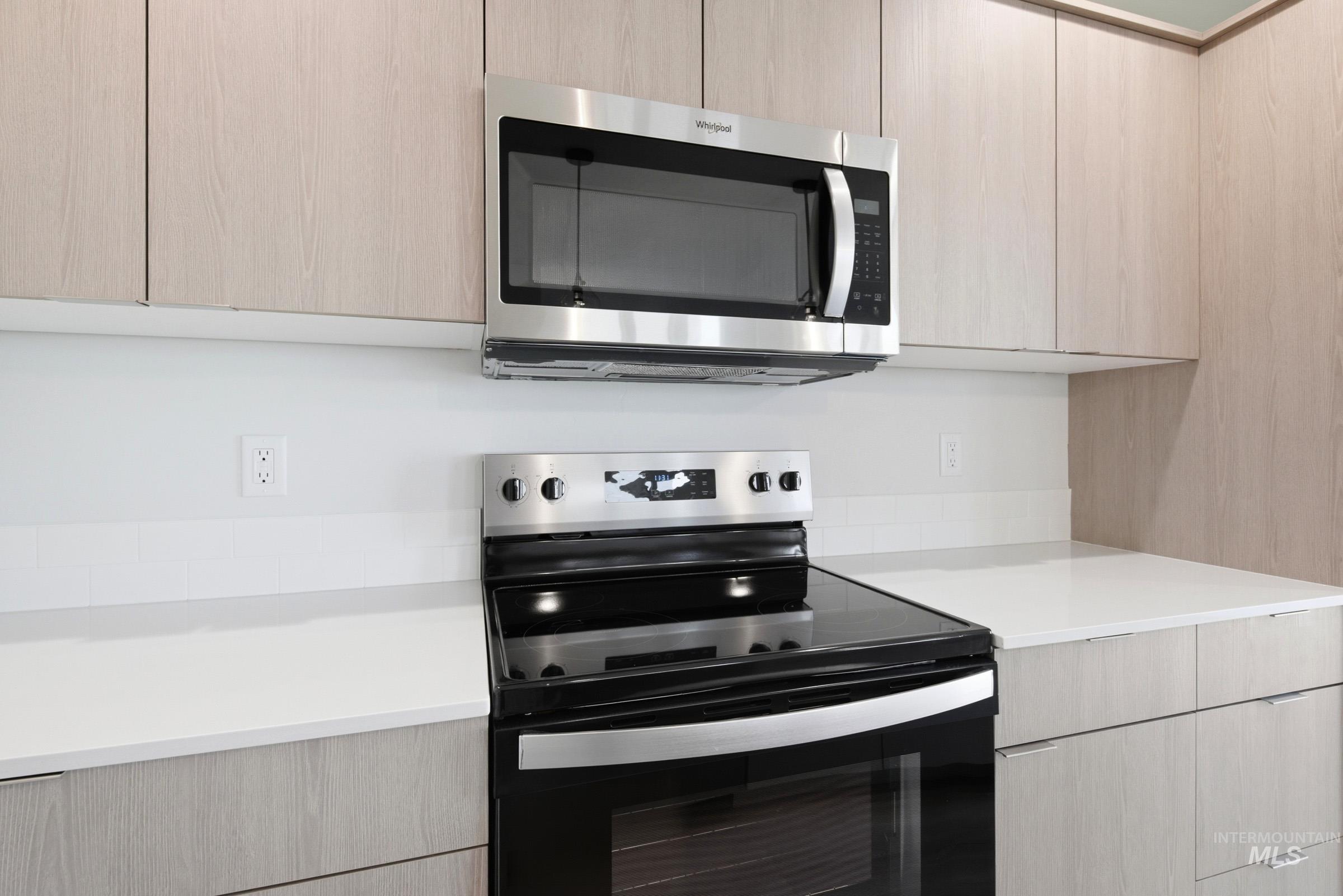 10794 Rutland Street Caldwell, ID 83605 - Photo 5 of 22 Stainless steel microwave and electric range with a glass cooktop, surrounded by light wood-finish cabinetry and white countertops