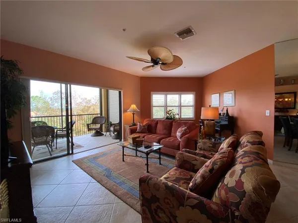 a living room with furniture a flat screen tv and a large window