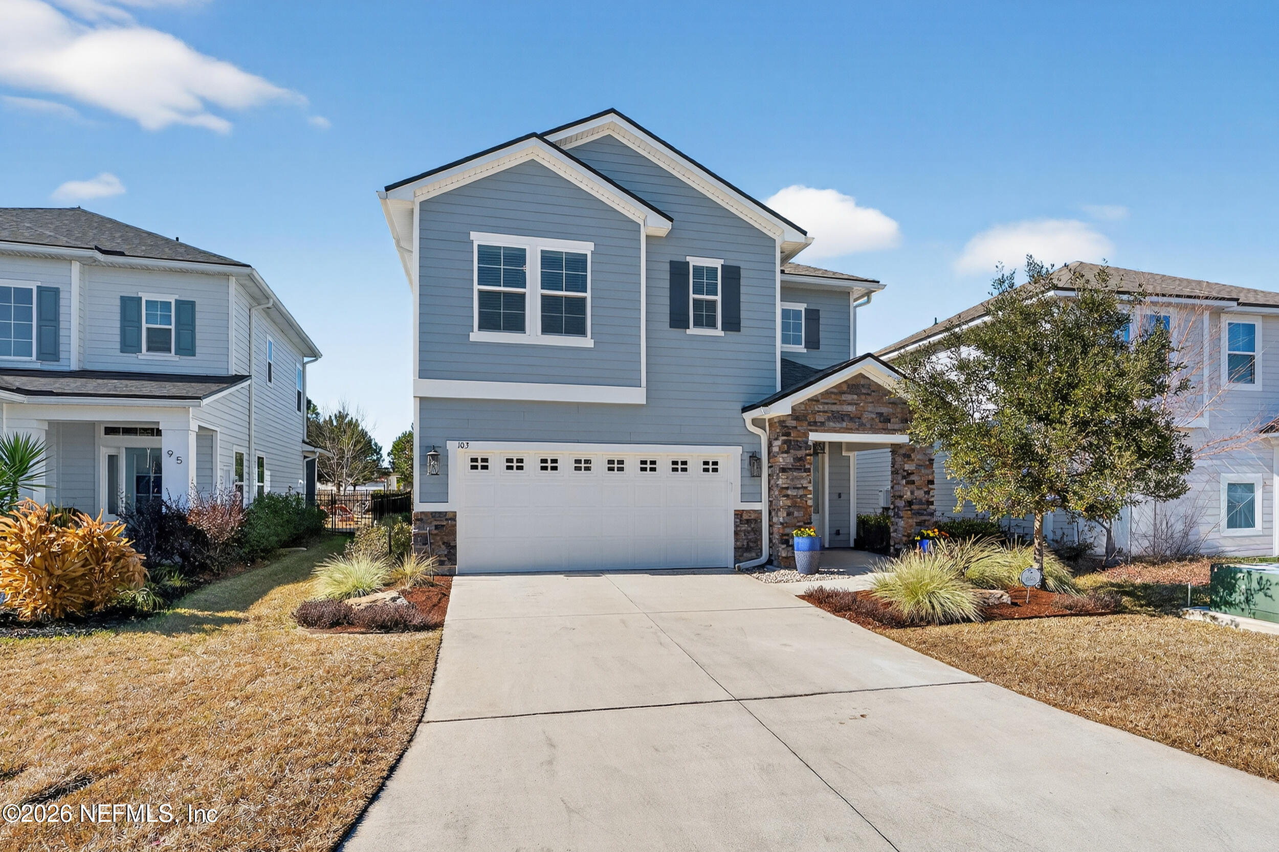 a front view of a house with a yard and garage