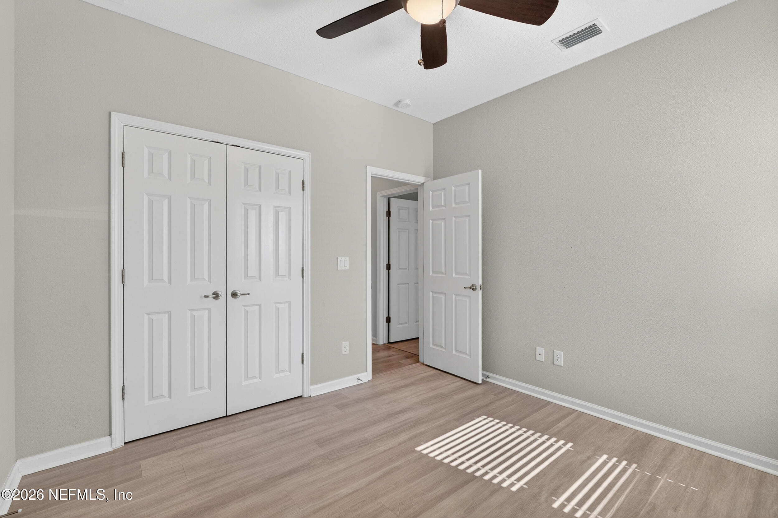 103 Ferndale Way St. Augustine, FL 32092 - Photo 28 of 54 an empty room with wooden floor chandelier fan and windows
