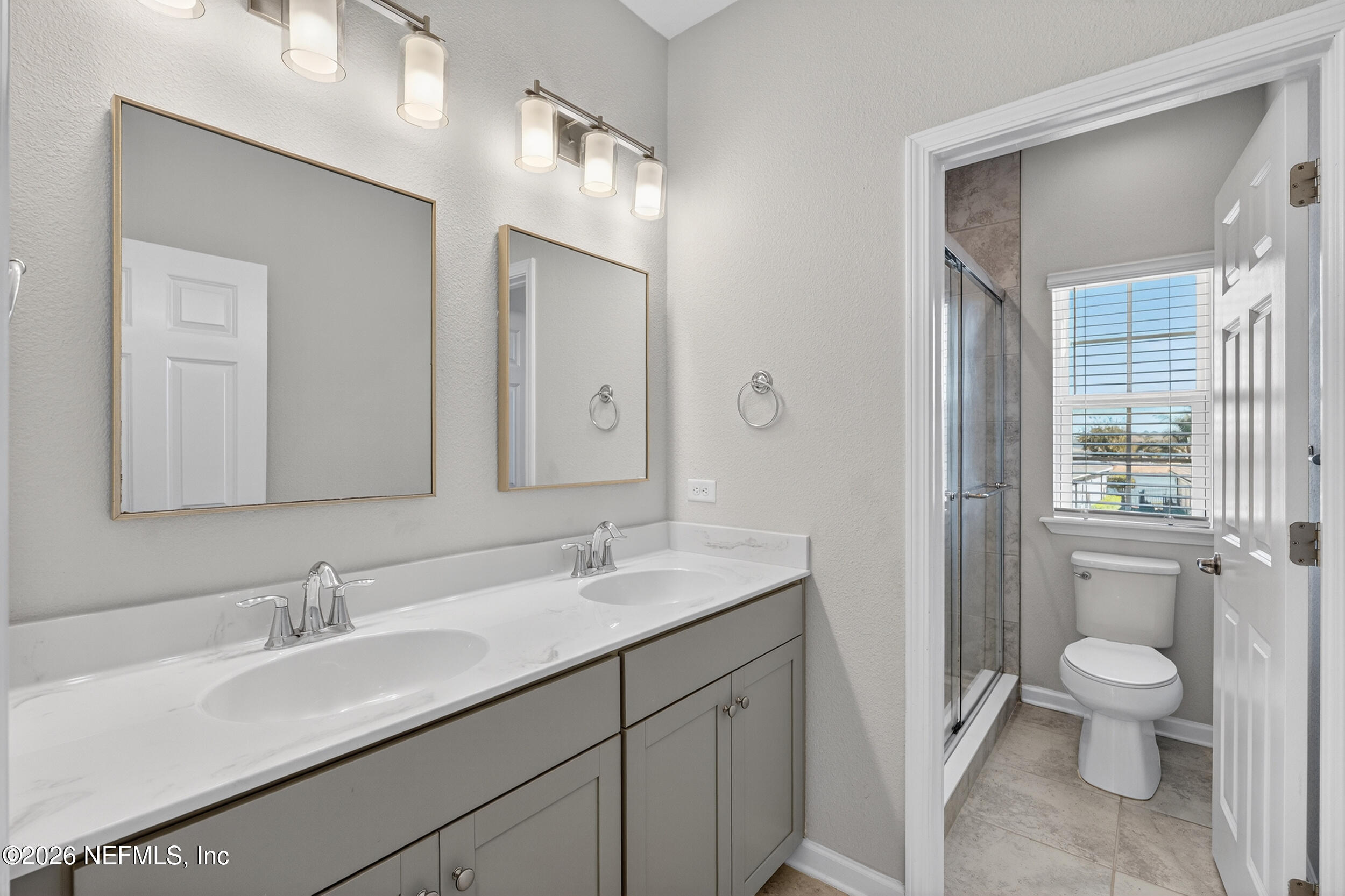103 Ferndale Way St. Augustine, FL 32092 - Photo 32 of 54 a bathroom with a toilet a sink a mirror and a shower