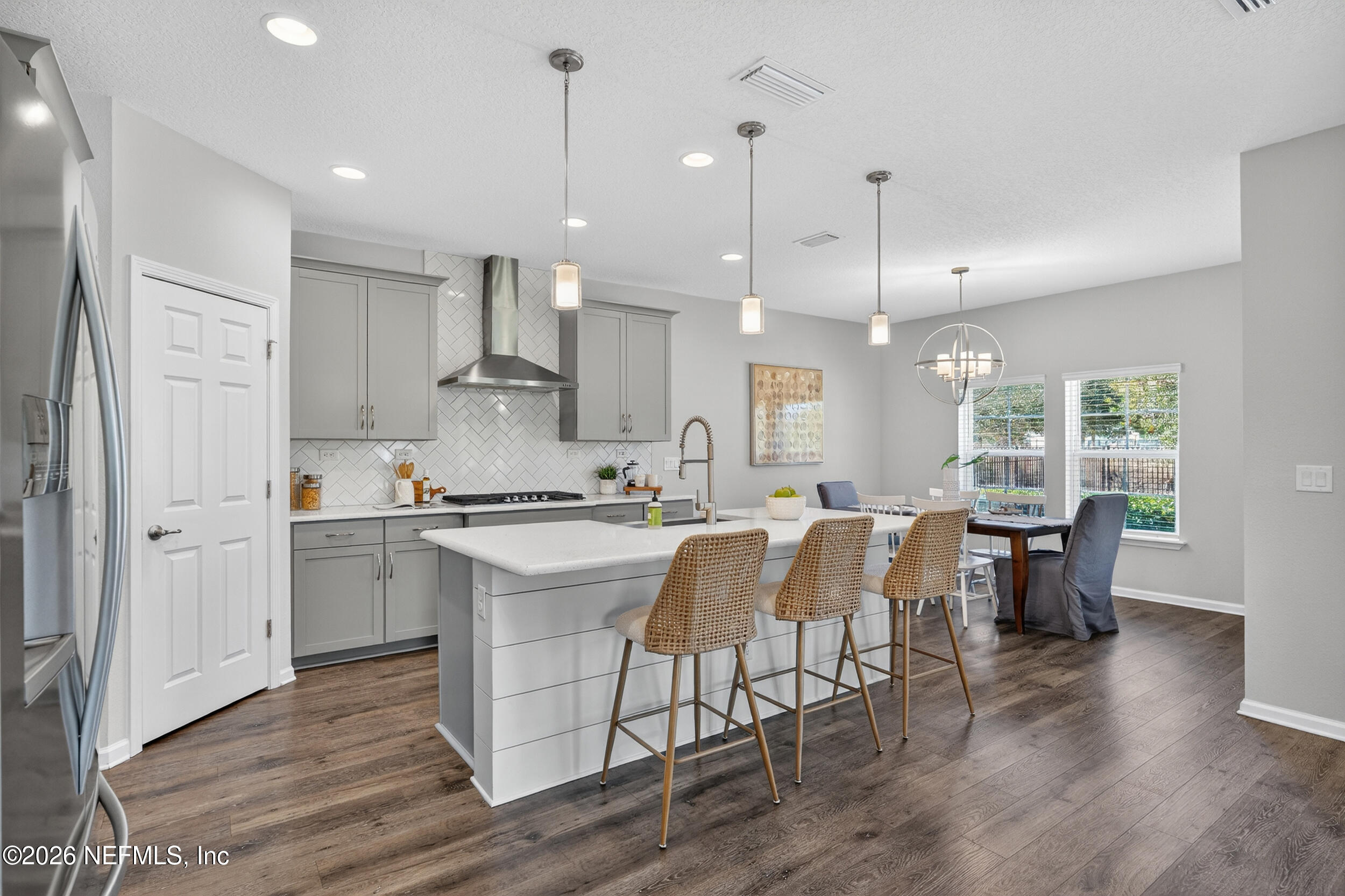 103 Ferndale Way St. Augustine, FL 32092 - Photo 5 of 54 a large kitchen with kitchen island a dining table chairs and wooden floor