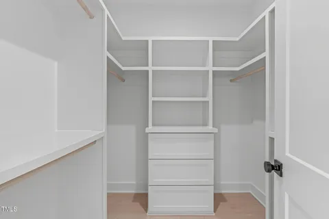 a view of walk in closet with empty racks