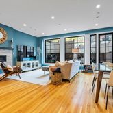 a living room with furniture a fireplace and a floor to ceiling window next to a large window