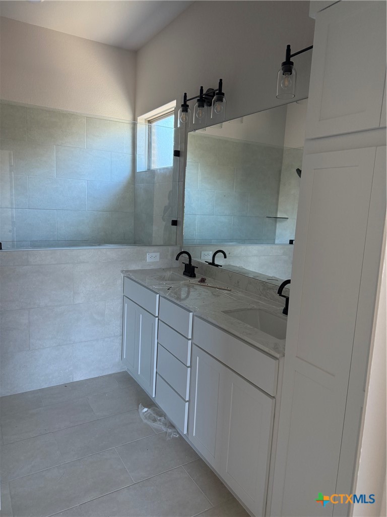 7102 Touchstone Drive Temple, TX 76502 - Photo 12 of 14 a bathroom with a granite countertop sink mirror and vanity