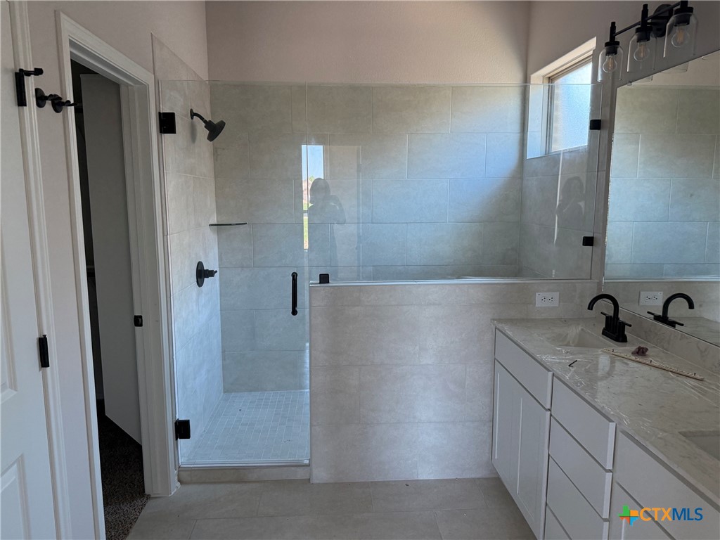 7102 Touchstone Drive Temple, TX 76502 - Photo 13 of 14 a bathroom with a granite countertop sink mirror and shower