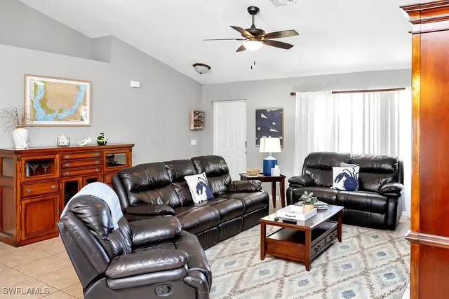a living room with furniture ceiling fan and a window