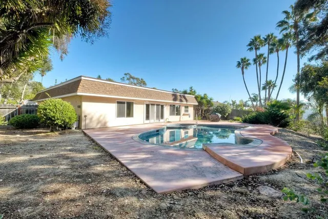 a front view of a house with a yard and potted plants