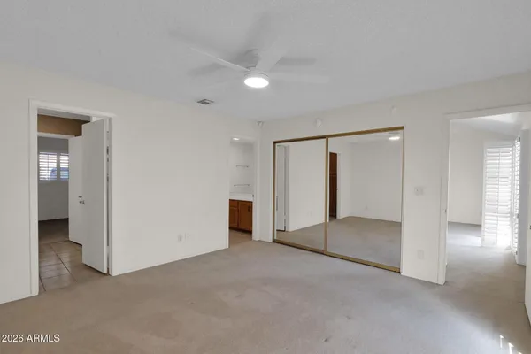 an empty room with a bathroom and mirror