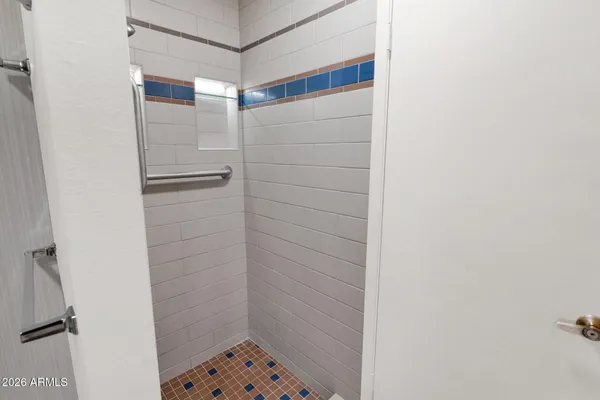 an empty room with chandelier fan and windows