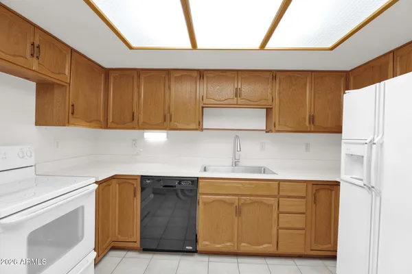 a kitchen with a sink a refrigerator and cabinets