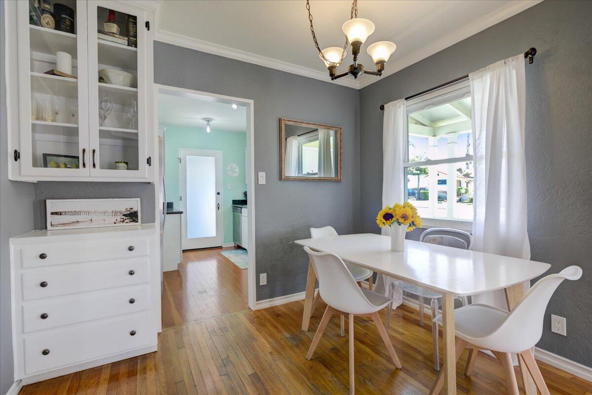 425 Howard Street Ventura, CA 93003 - Photo 13 of 31 a dining room with wooden floor a chandelier a wooden table and chairs