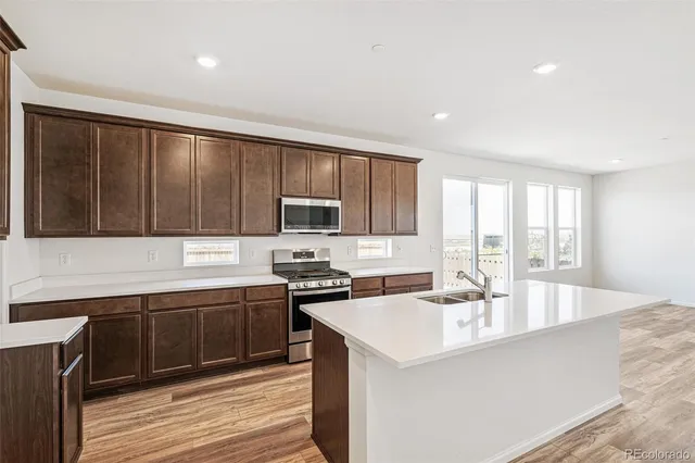a kitchen with a sink a stove a refrigerator and a cabinets