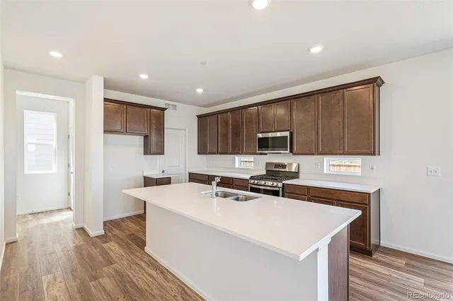 a kitchen with granite countertop a sink stove and cabinets