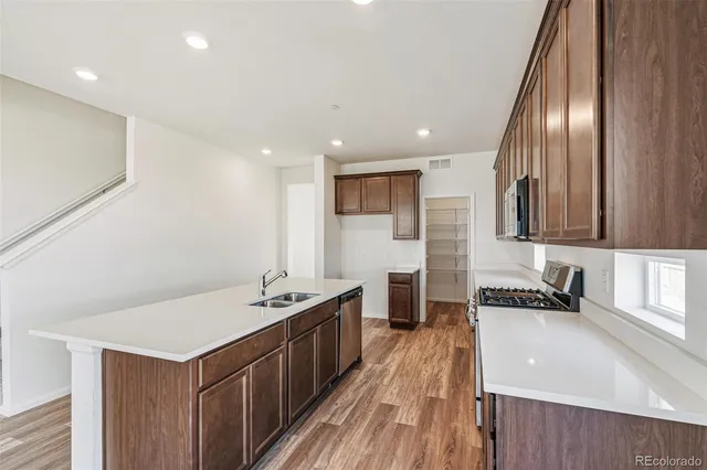 a kitchen with stainless steel appliances granite countertop a sink stove and refrigerator