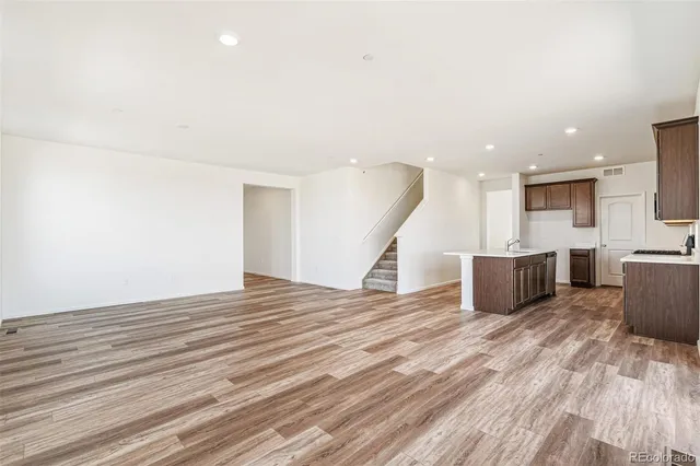 a view of a kitchen with wooden floor and a sink