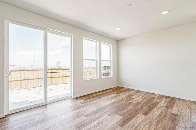 a large white kitchen with a large window a sink and stainless steel appliances