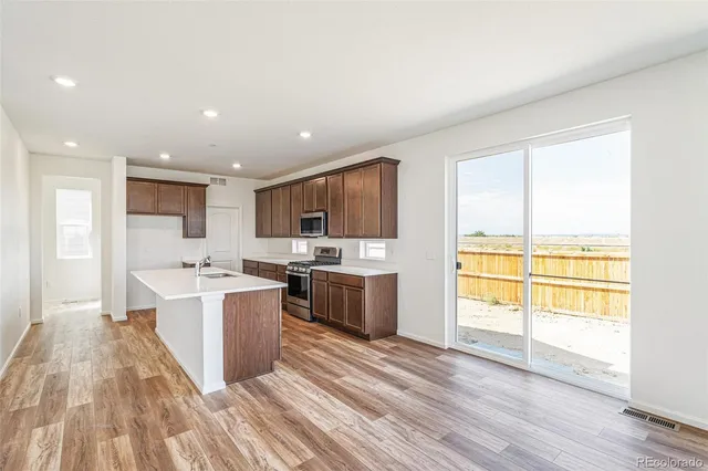 a kitchen with stainless steel appliances a sink stove and cabinets