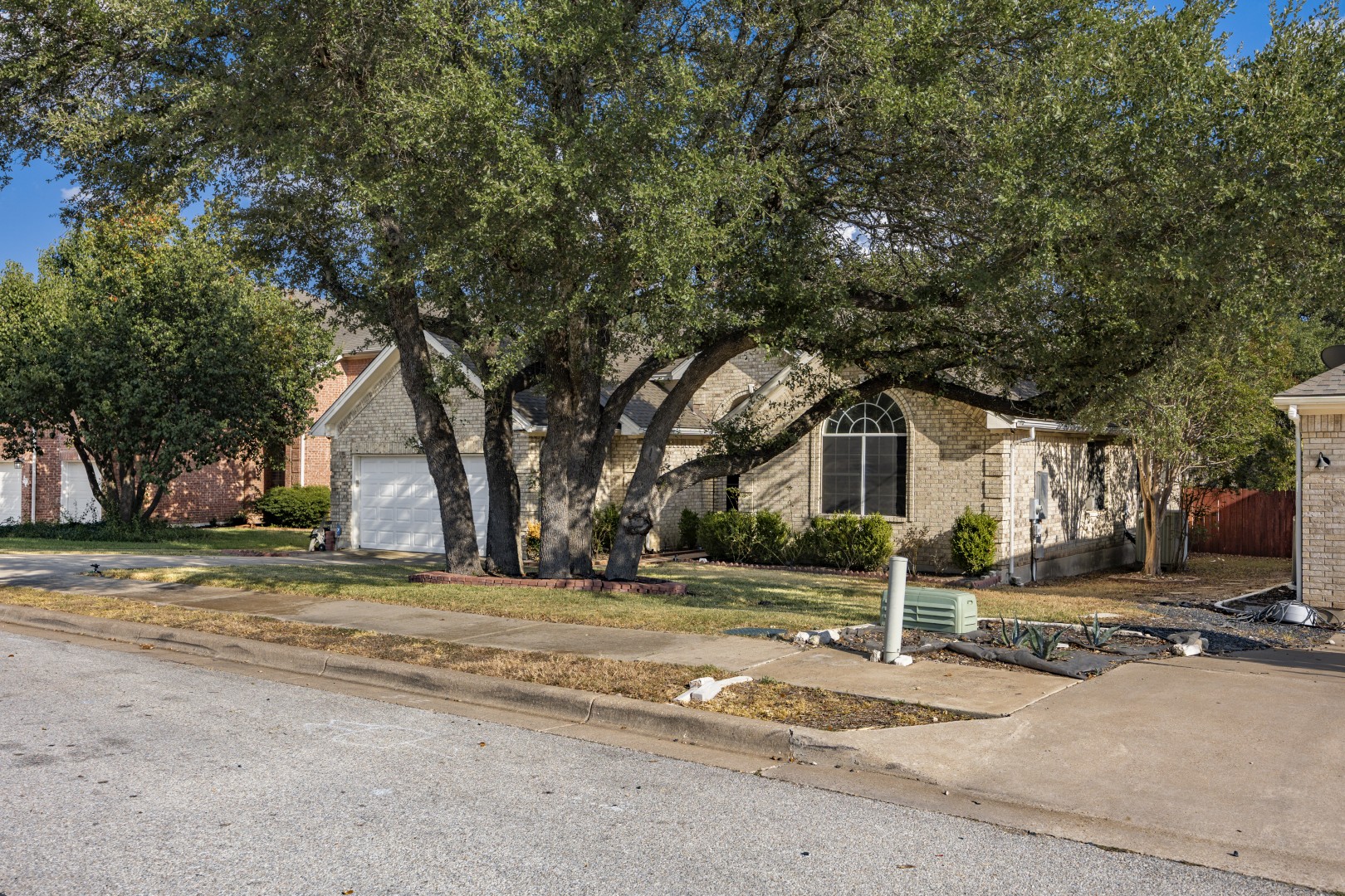 1108 Antelope Ridge Cedar Park, TX 78613 - Photo 38 of 39 Mature shade trees frame the classic brick exterior and private driveway of this suburban home.