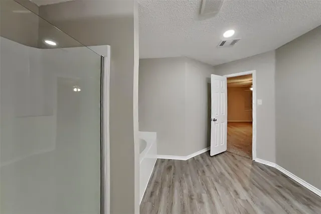 a view of empty room with wooden floor