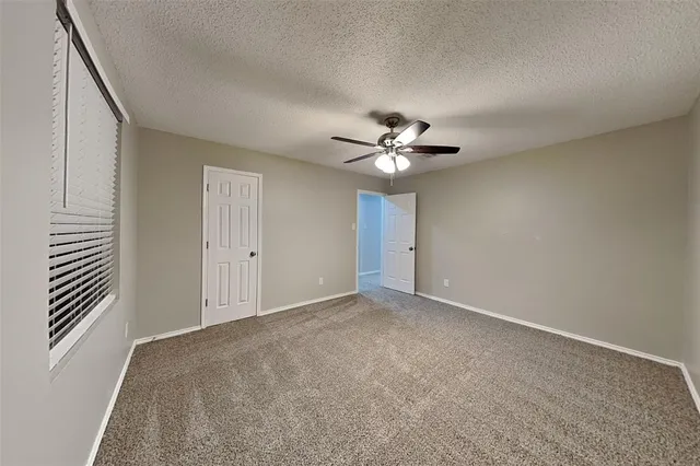 a view of an empty room with a chandelier fan