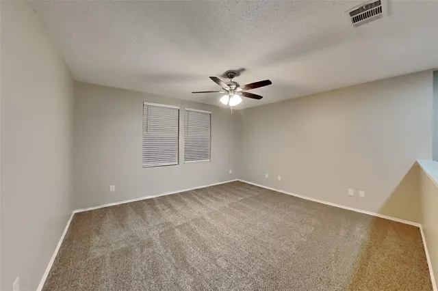 a view of an empty room with a ceiling fan