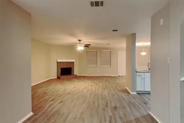 a view of empty room with wooden floor and fireplace