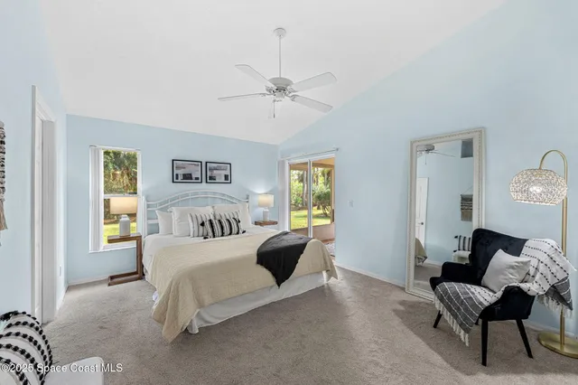 a bedroom with a bed couches and potted plant on table