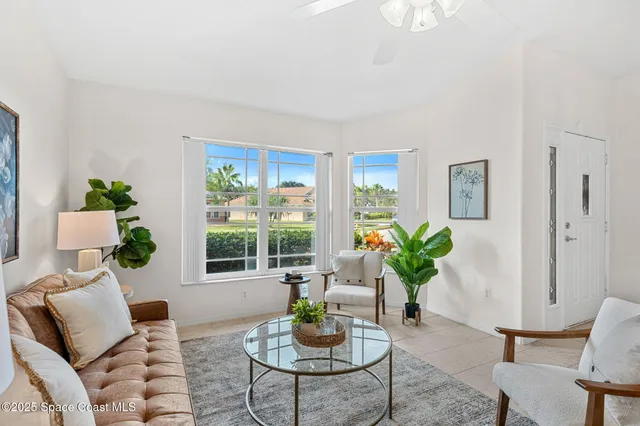 a living room with furniture potted plant and windows